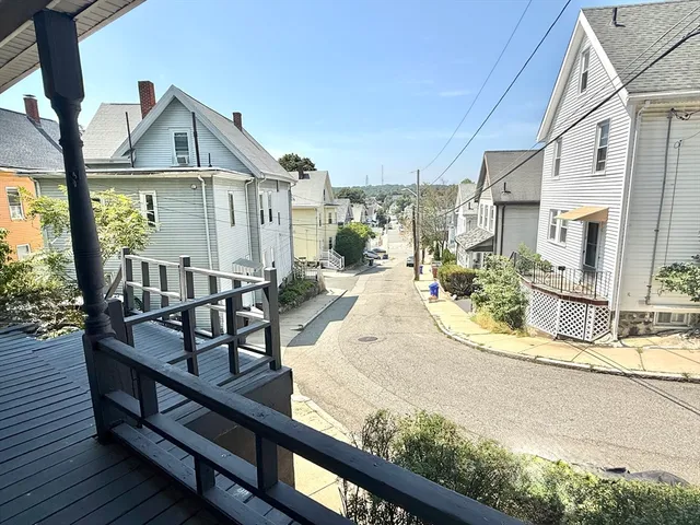 a view of a house with wooden deck and furniture