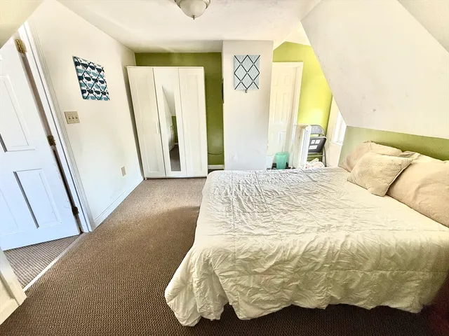 a large bed sitting in a bedroom next to a window