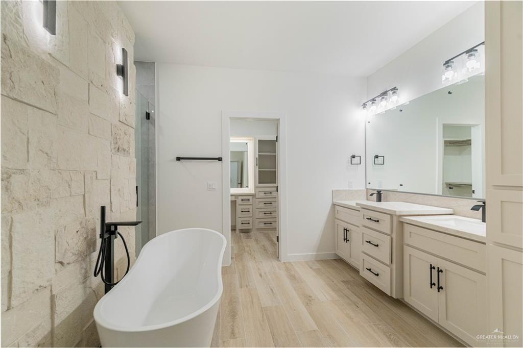 9804 North 25th Street McAllen, TX 78504 - Photo 16 of 18 a en suite bathroom with a double vanity sink a mirror a toilet and a shower
