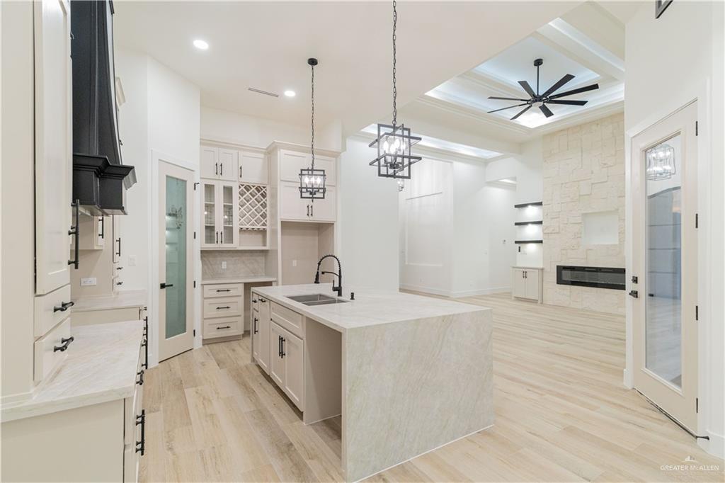 9804 North 25th Street McAllen, TX 78504 - Photo 7 of 18 a large white kitchen with a sink stainless steel appliances and a chandelier