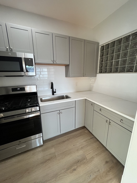 108 Bristol Road, Unit 1 Somerville, MA 02144 - Photo 6 of 24 a kitchen with a sink stove and cabinets