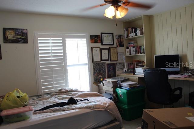 34321 South Haines Creek Road Leesburg, FL 34788 - Photo 13 of 19 a bedroom with a bed and a bookshelf