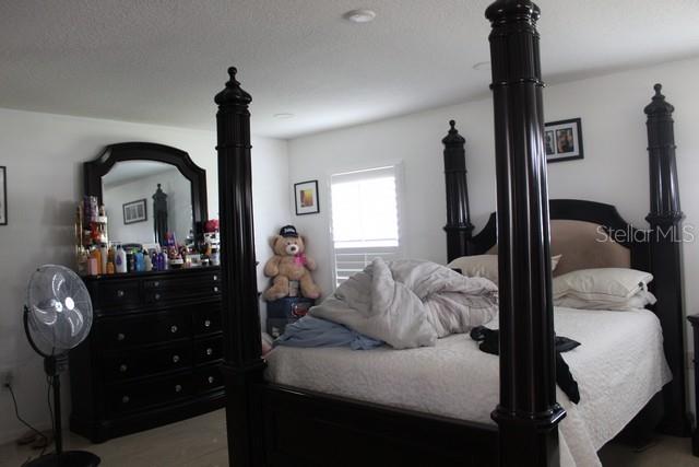 34321 South Haines Creek Road Leesburg, FL 34788 - Photo 15 of 19 a bedroom with a bed and a mirror