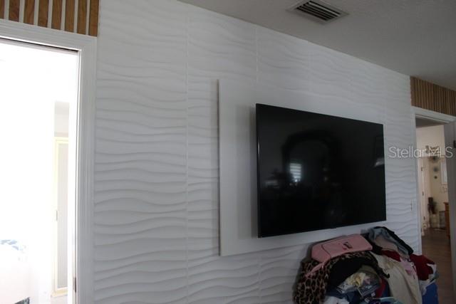 34321 South Haines Creek Road Leesburg, FL 34788 - Photo 5 of 19 a bedroom with a bed and a tv on the dresser