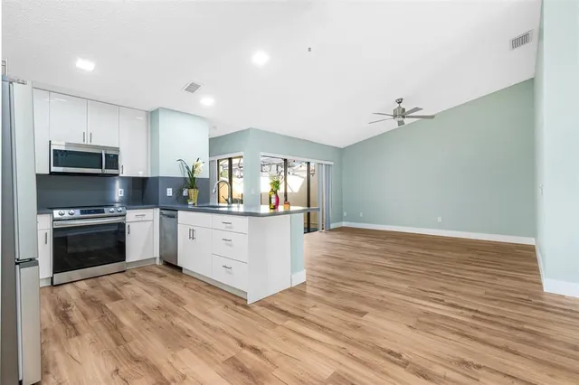 a kitchen with granite countertop a stove top oven and cabinets