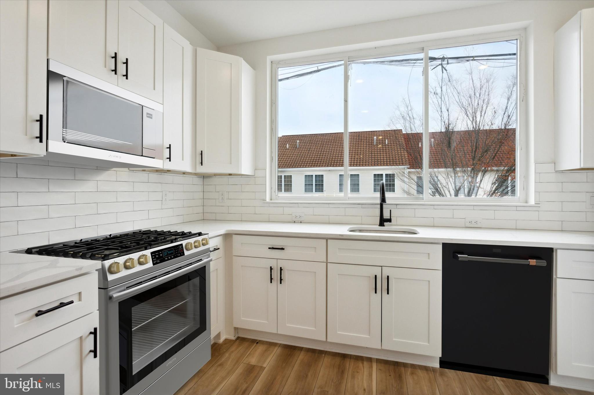a kitchen with white cabinets and a stove top oven