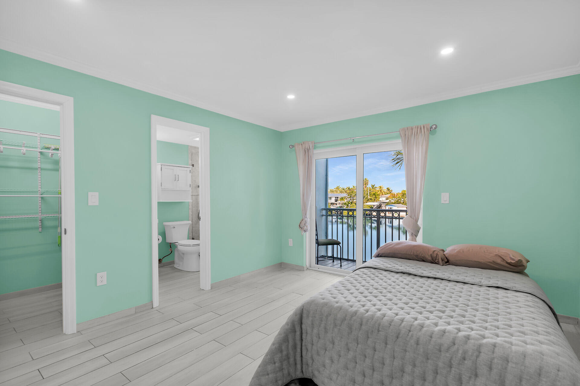 201 Coppitt Road, Unit 202C Key West, FL 33040 - Photo 15 of 31 a bedroom with a large bed and a chandelier