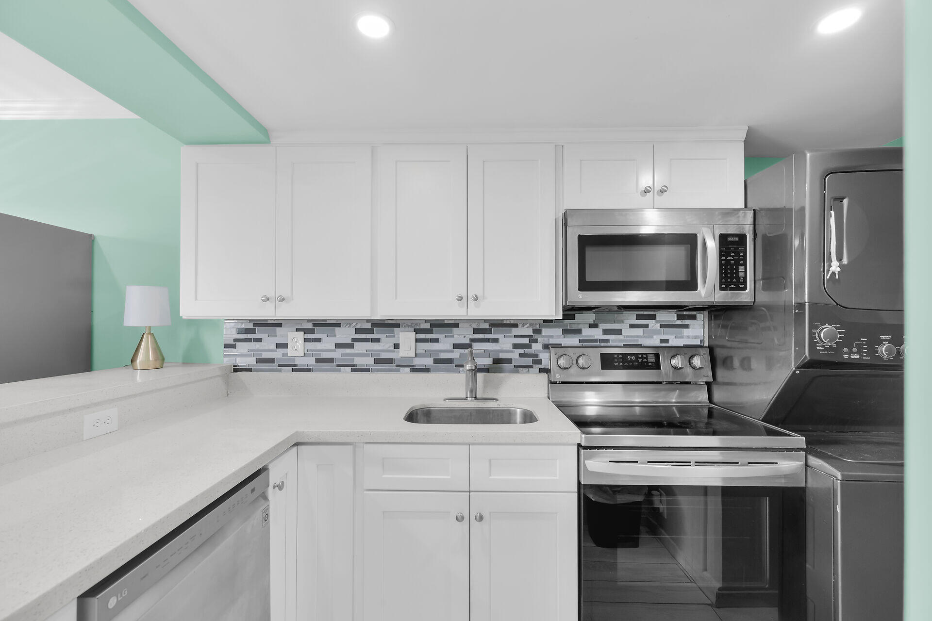 201 Coppitt Road, Unit 202C Key West, FL 33040 - Photo 9 of 31 a kitchen with a sink and a stove top oven with wooden floor