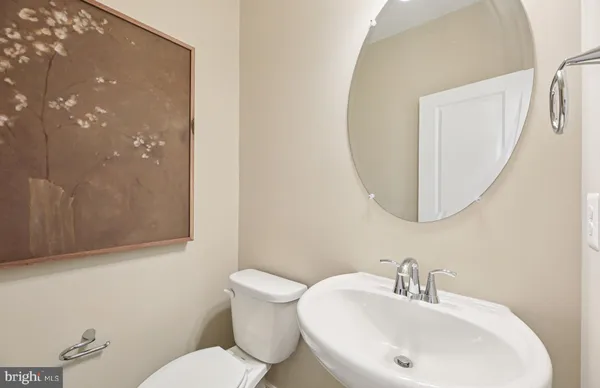 a bathroom with a sink and mirror with toilet