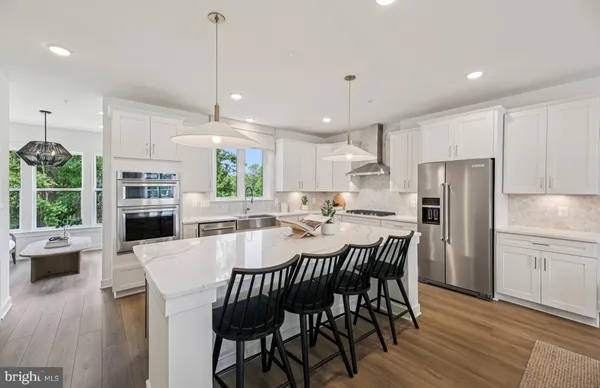 a view of a dining room with furniture a kitchen and chandelier