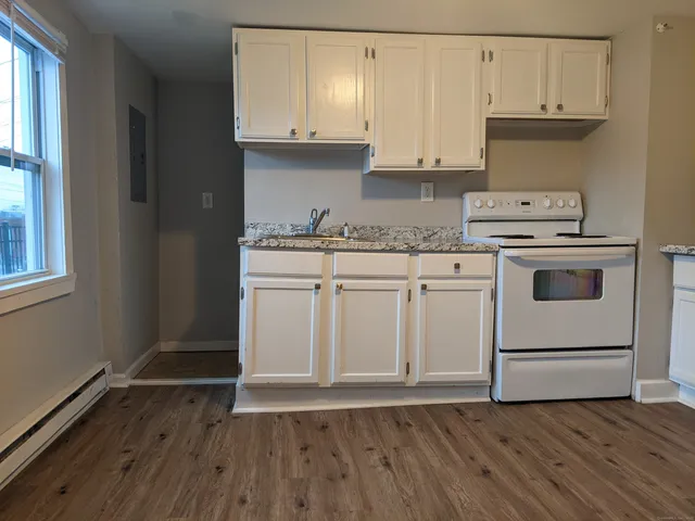 a kitchen with granite countertop wooden cabinets and white appliances