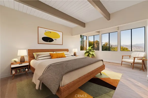 a bedroom with a bed a couch and a large window