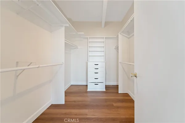a view of walk in closet with empty racks