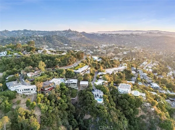 an aerial view of residential houses with outdoor space and trees