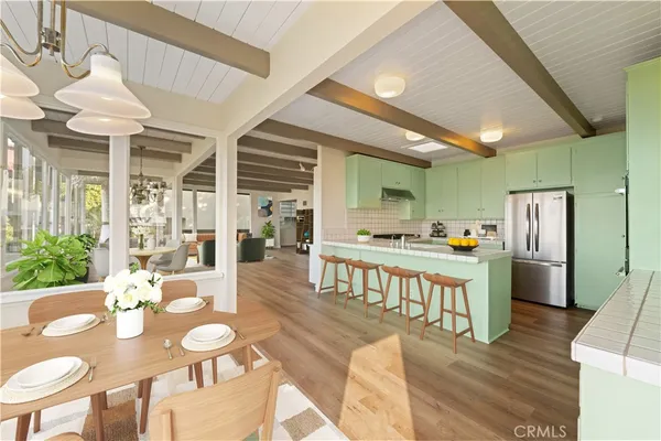 a kitchen with stainless steel appliances kitchen island granite countertop a table chairs and a living room