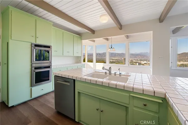 a kitchen with kitchen island granite countertop wooden cabinets and stainless steel appliances