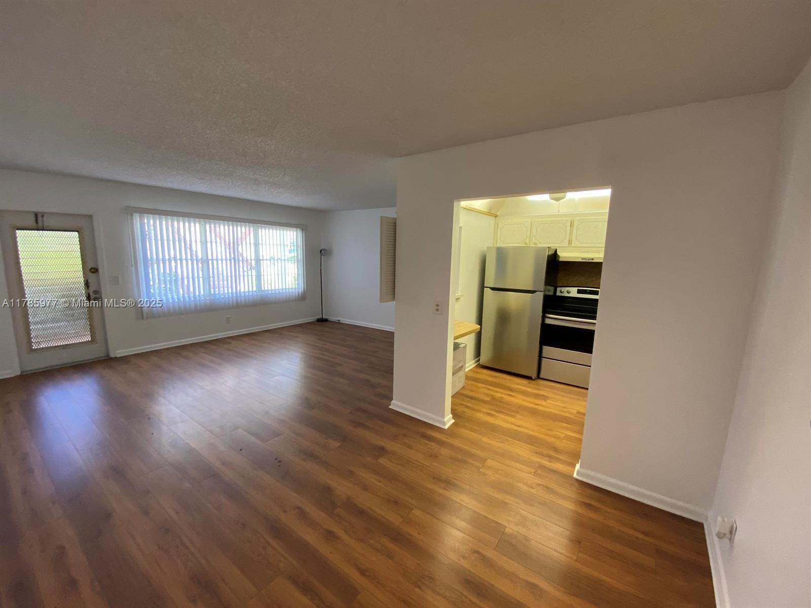 381 Fanshaw J, Unit 381 Boca Raton, FL 33434 - Photo 11 of 13 an empty room with wooden floor and windows