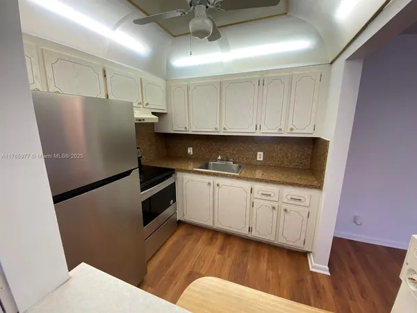 a kitchen with stainless steel appliances a refrigerator sink and cabinets
