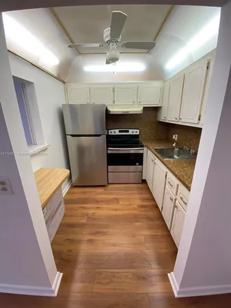 a kitchen with granite countertop a refrigerator and a sink