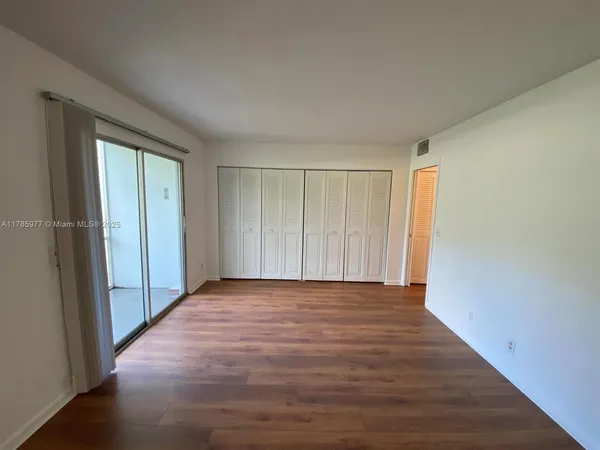 a view of an empty room with wooden floor