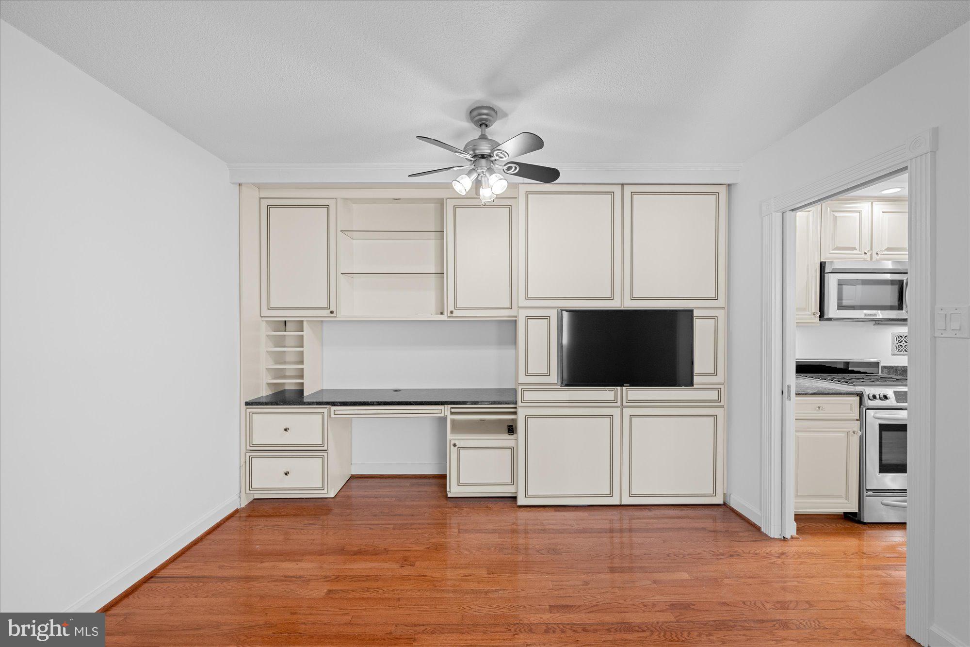 5500 Friendship Boulevard, Unit 2114N Chevy Chase, MD 20815 - Photo 12 of 19 a living room with stainless steel appliances a kitchen island a stove a microwave a sink and white cabinets