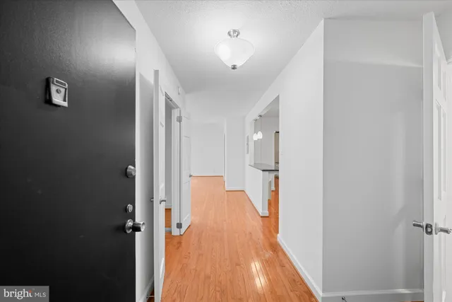 a view of a hallway with wooden floor and closet