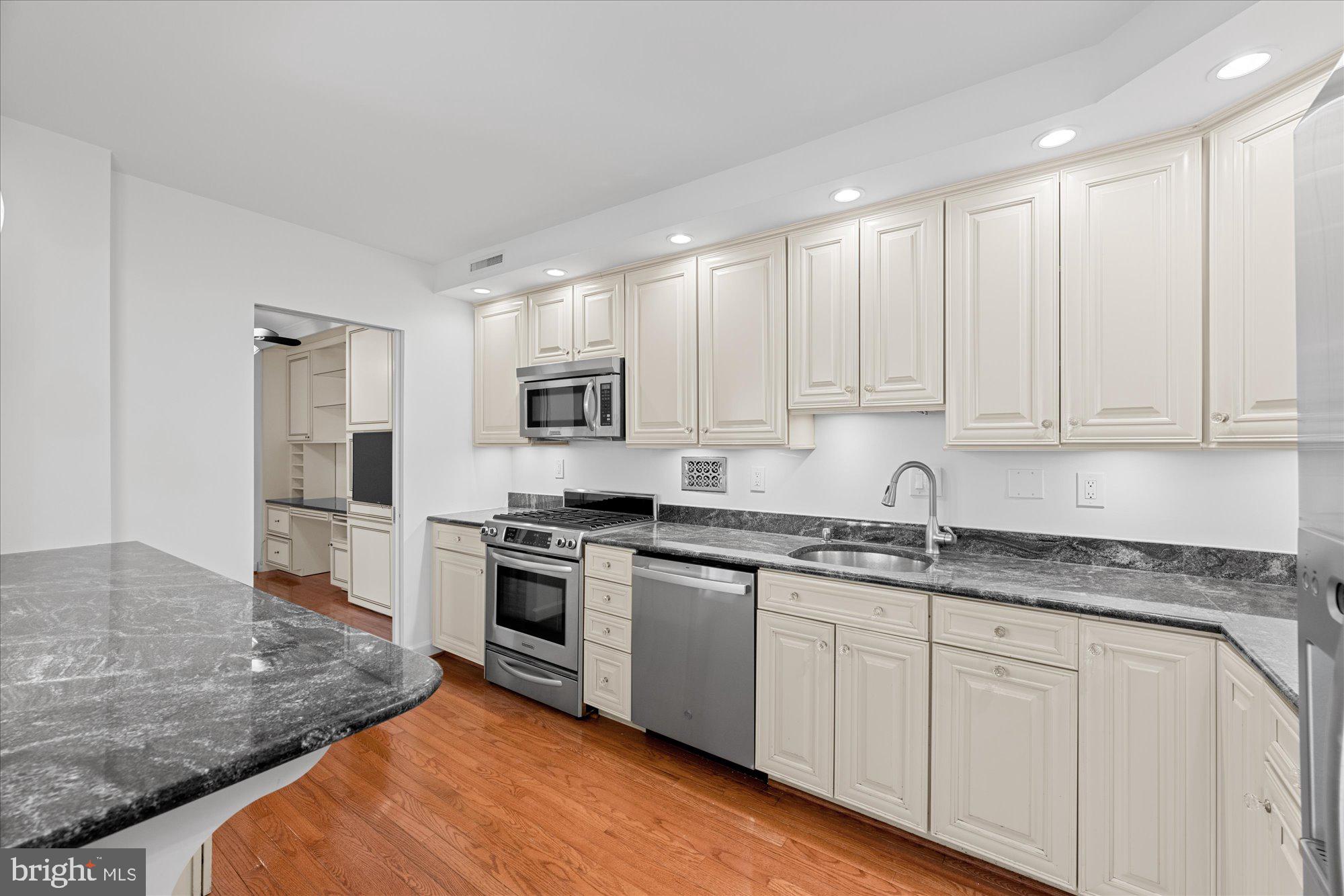 5500 Friendship Boulevard, Unit 2114N Chevy Chase, MD 20815 - Photo 7 of 19 a kitchen with granite countertop white cabinets and stainless steel appliances