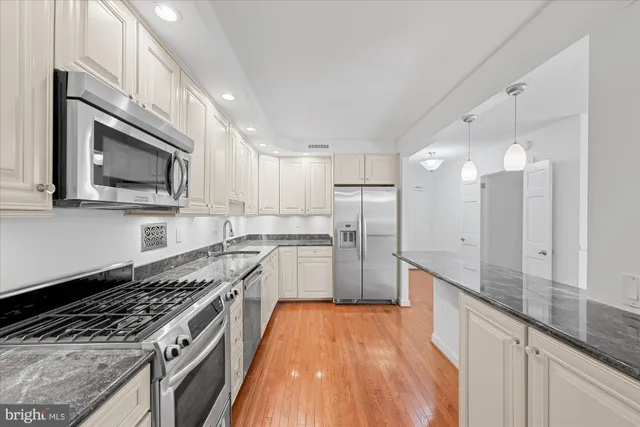 a large kitchen with stainless steel appliances granite countertop a stove a sink and a refrigerator
