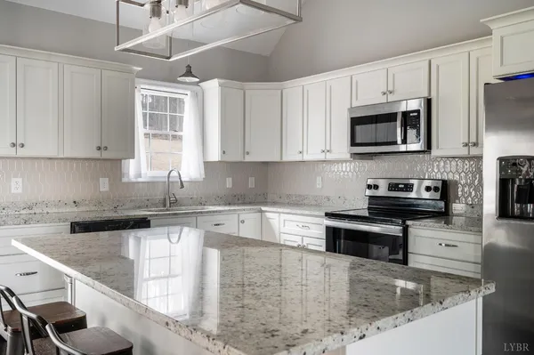 a kitchen with stainless steel appliances granite countertop a stove a sink and a microwave