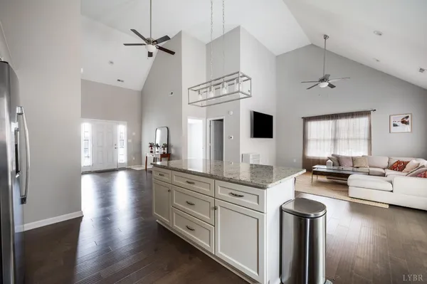 a kitchen with stainless steel appliances a stove a sink dishwasher a refrigerator and a fireplace with wooden floor