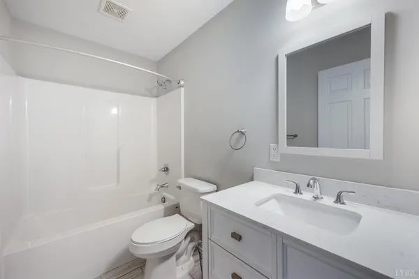 a bathroom with a granite countertop sink a toilet and a mirror
