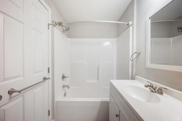 a bathroom with a bathtub shower sink vanity and a toilet