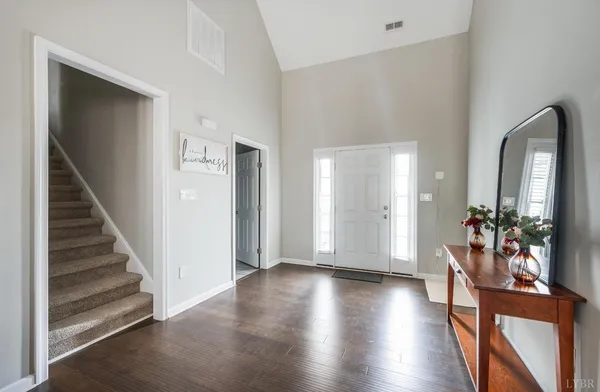 a view of a hallway with wooden floor and stairs