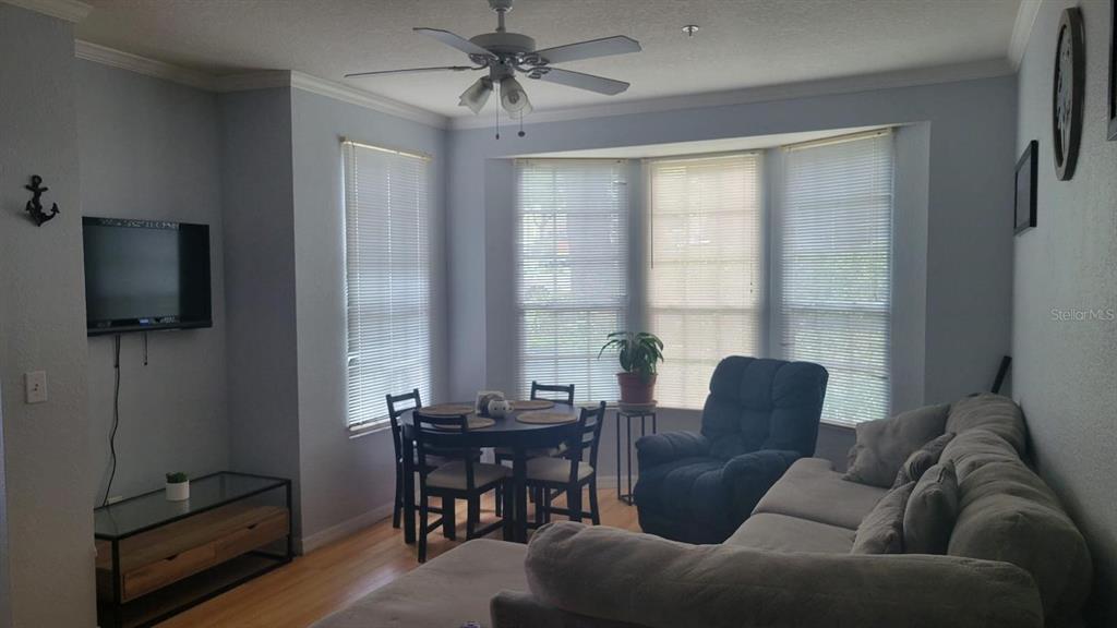 6316 Raleigh Street, Unit 401 Orlando, FL 32835 - Photo 3 of 6 a living room with furniture a flat screen tv and a window