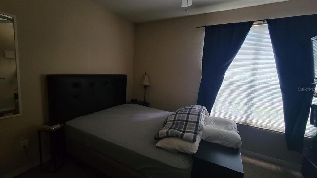 6316 Raleigh Street, Unit 401 Orlando, FL 32835 - Photo 5 of 6 a bedroom with a bed and a window