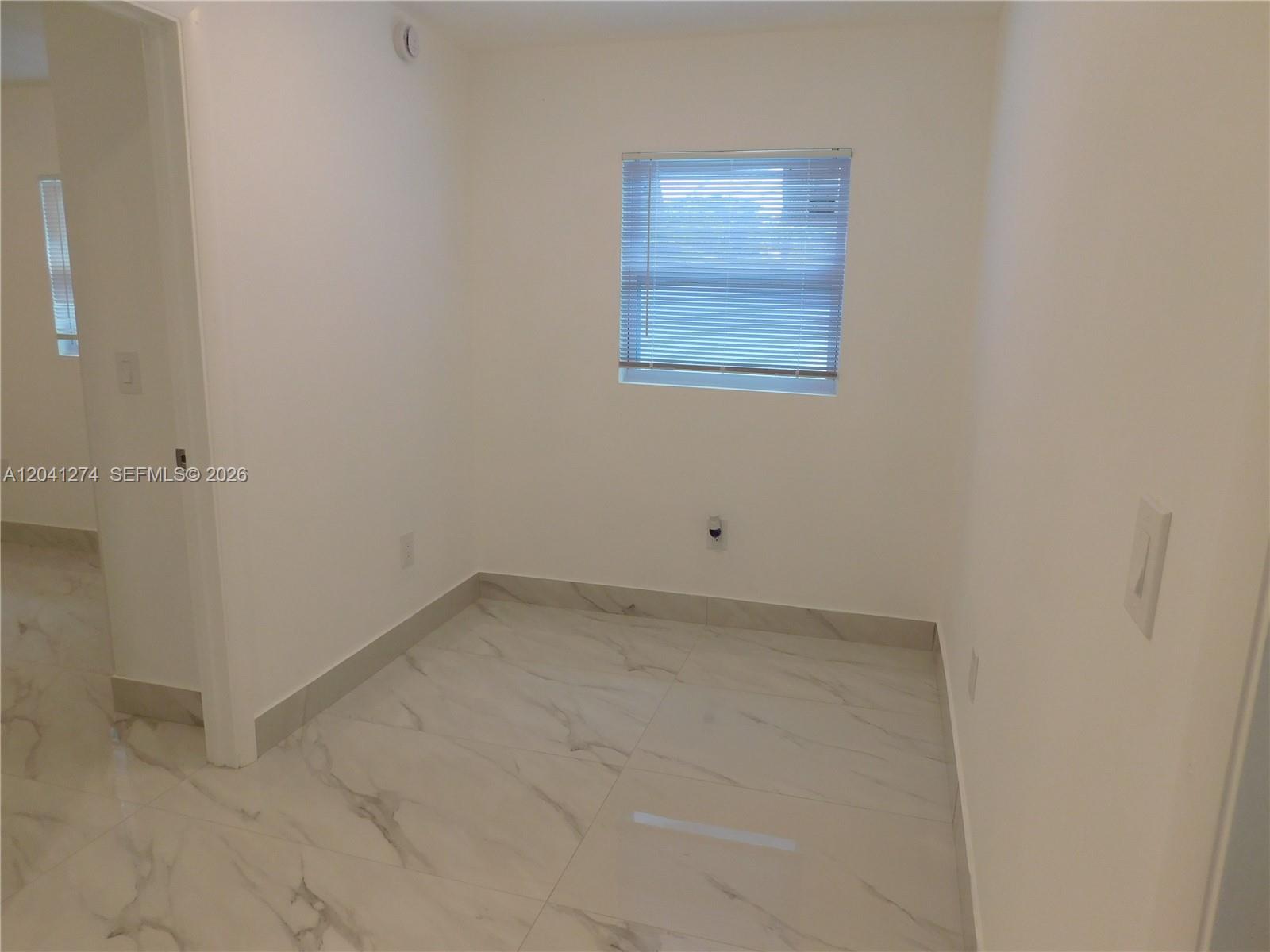 2230 Northwest 58th Street, Unit B Miami, FL 33142 - Photo 10 of 18 an empty room with a bench