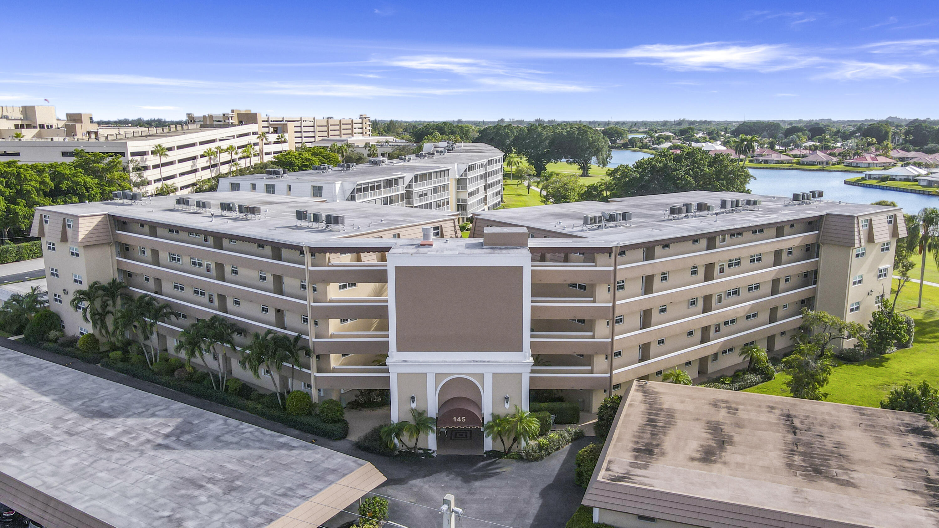 145 Atlantis Boulevard, Unit 105 Atlantis, FL 33462 - Photo 2 of 28 a view of a building with a garden