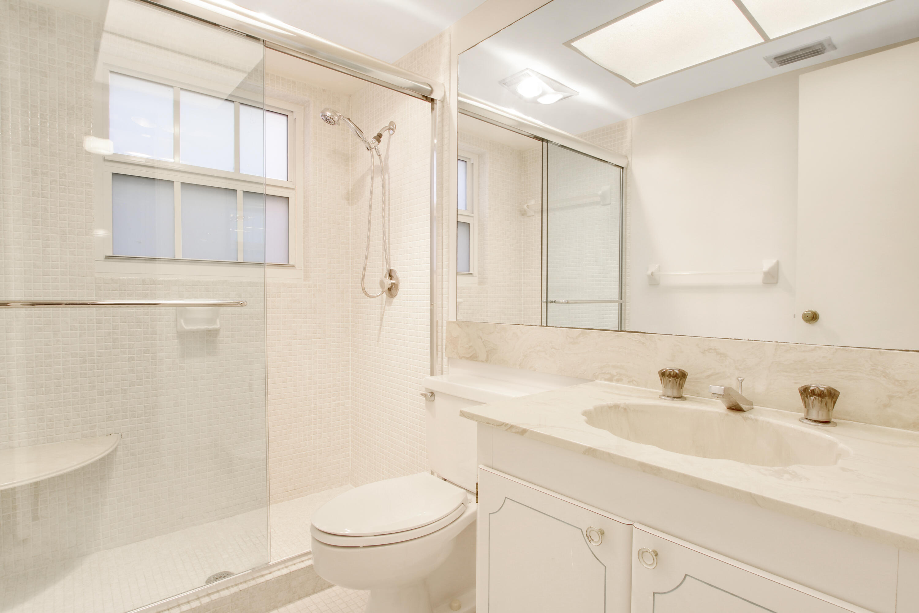 145 Atlantis Boulevard, Unit 105 Atlantis, FL 33462 - Photo 24 of 28 a bathroom with a sink toilet and shower