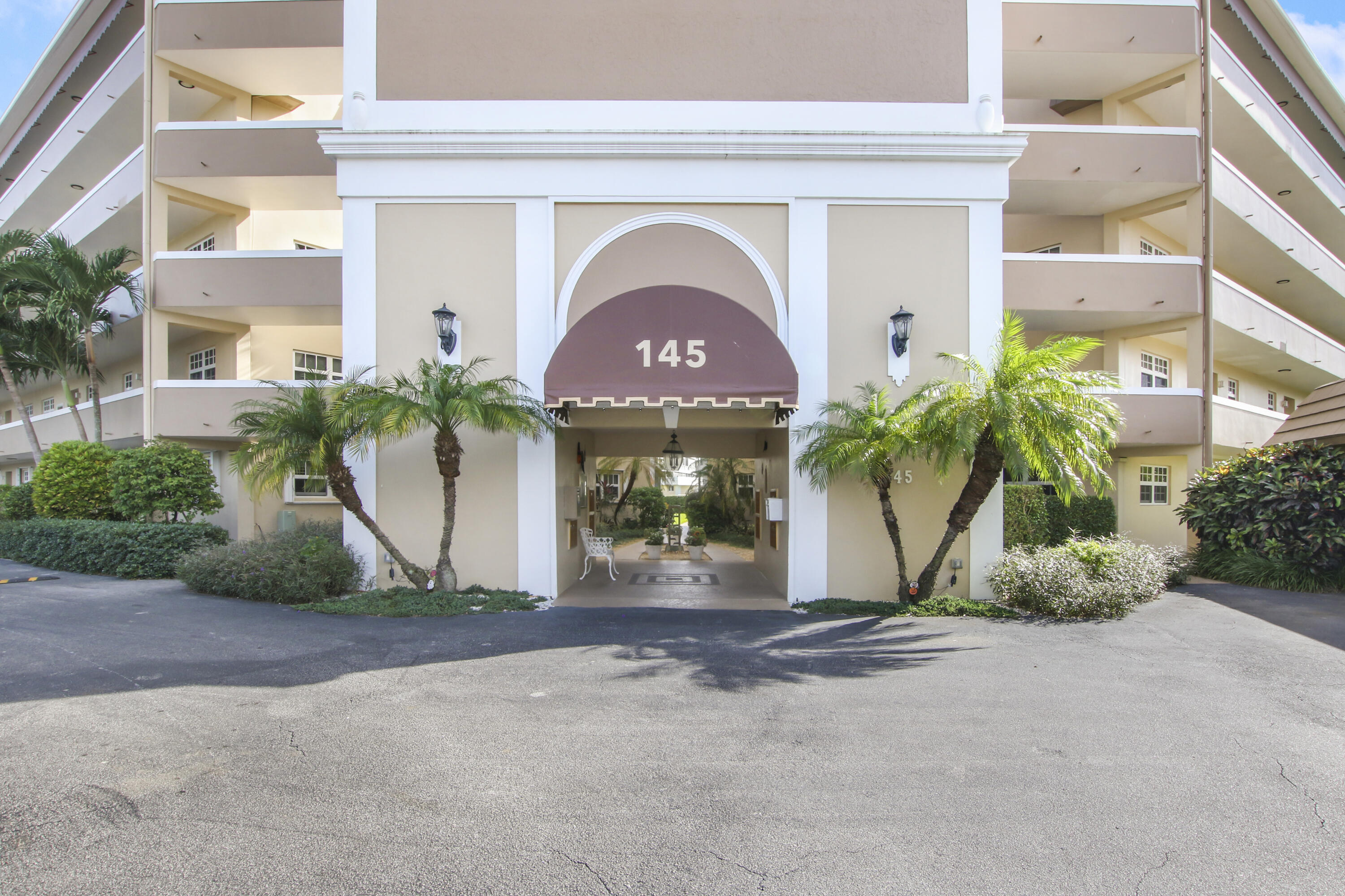 145 Atlantis Boulevard, Unit 105 Atlantis, FL 33462 - Photo 4 of 28 a front view of a house with a yard