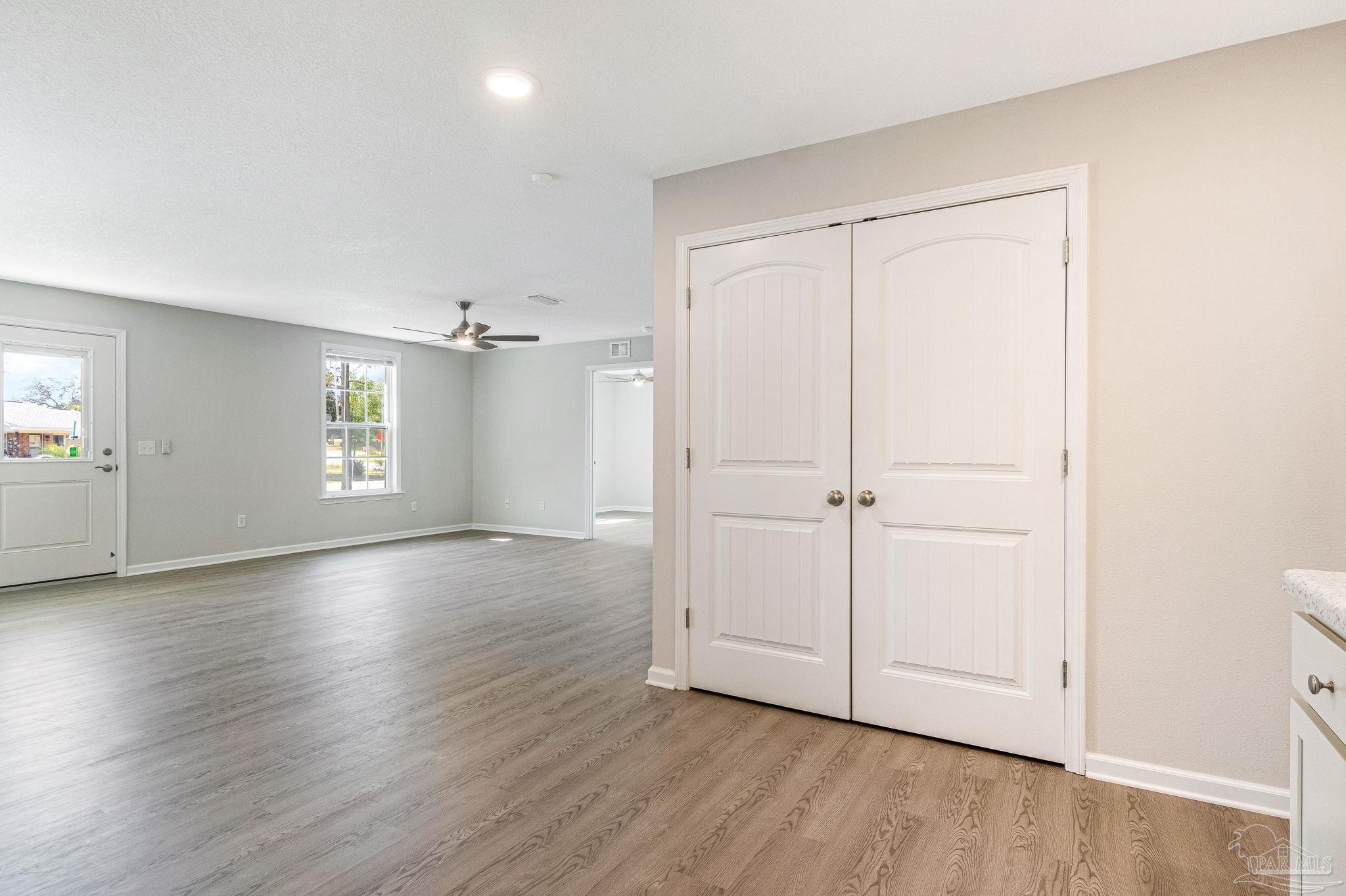 3152 Clemson Road Gulf Breeze, FL 32563 - Photo 12 of 56 an empty room with wooden floor and windows