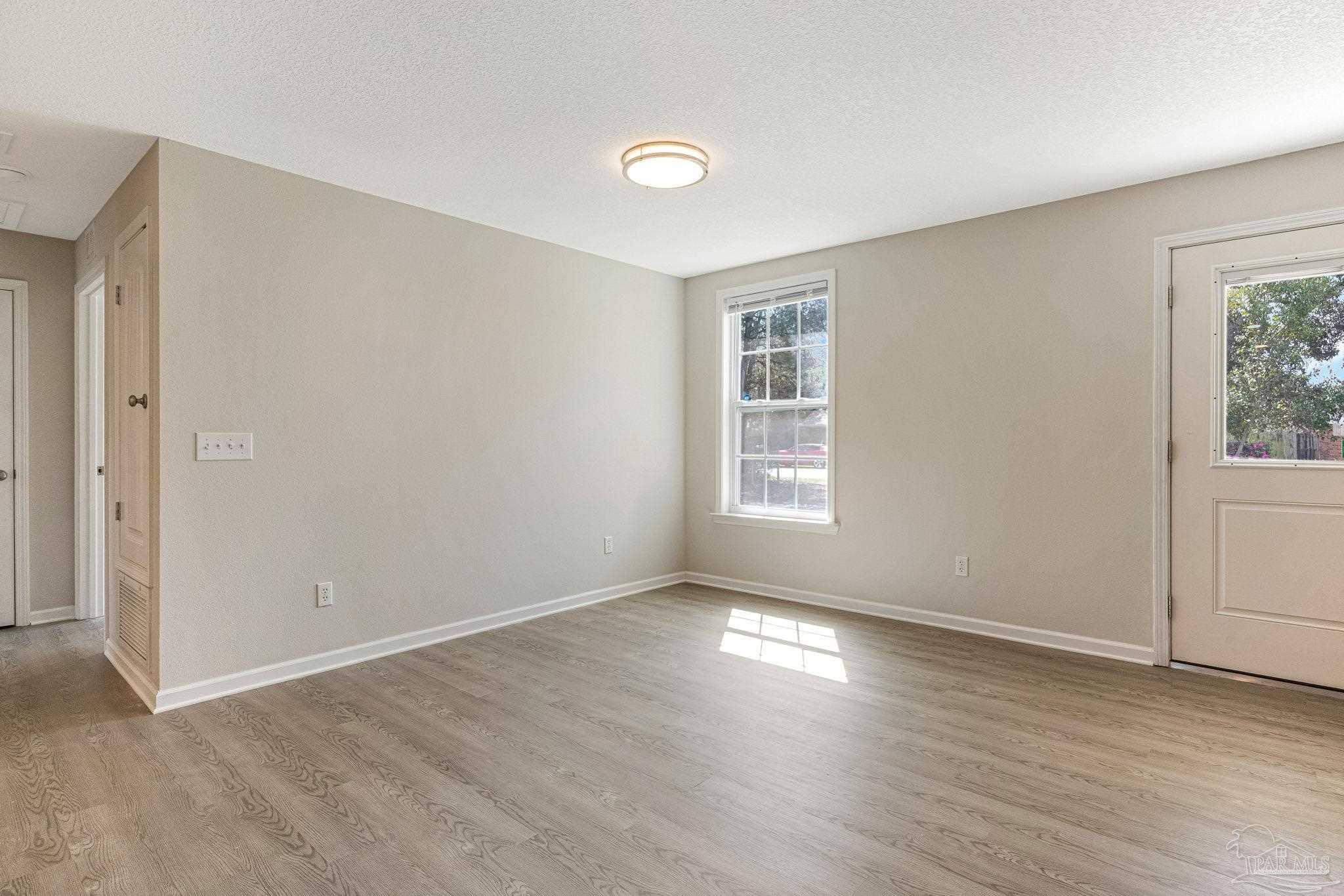 3152 Clemson Road Gulf Breeze, FL 32563 - Photo 17 of 56 an empty room with wooden floor and windows