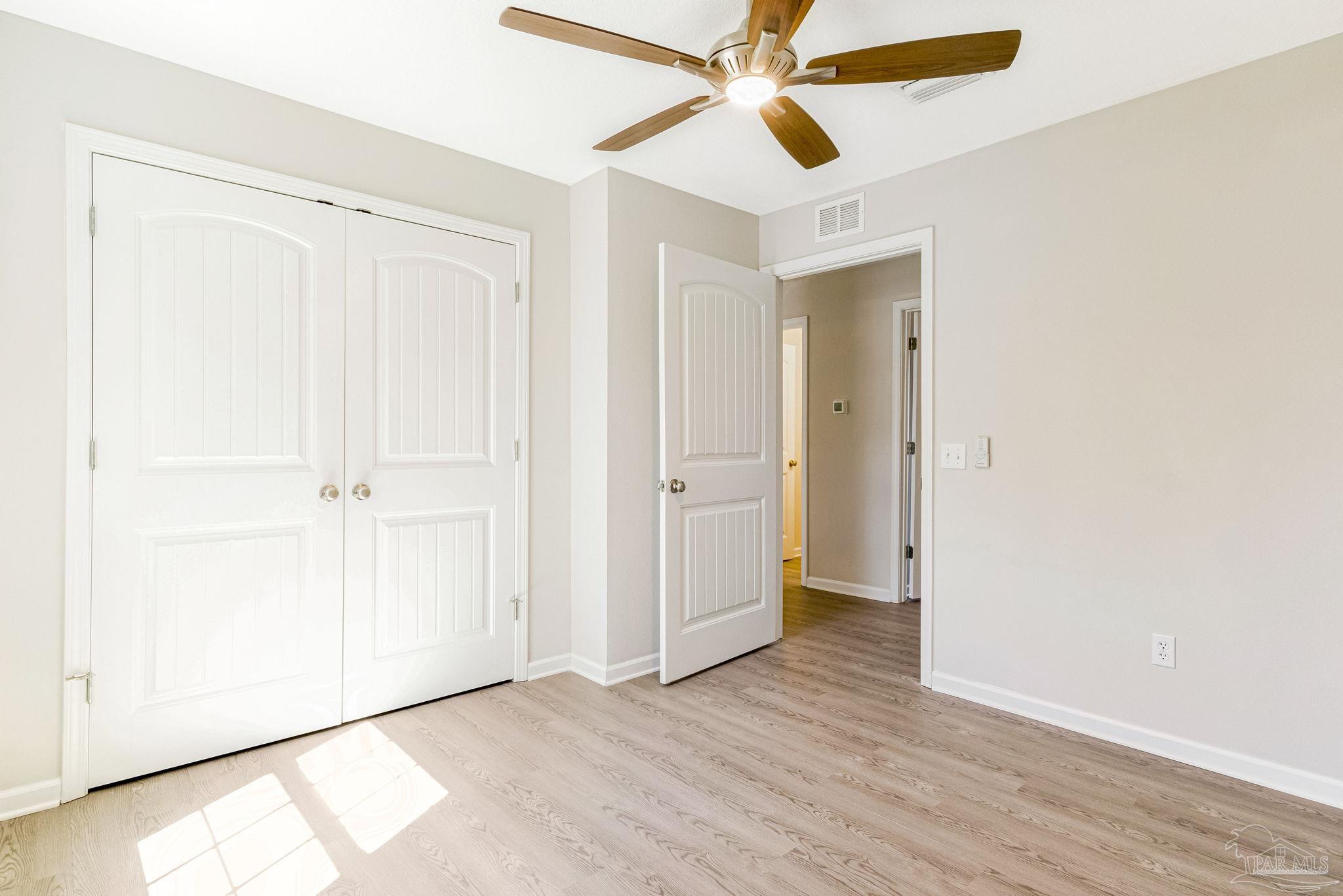 3152 Clemson Road Gulf Breeze, FL 32563 - Photo 20 of 56 an empty room with wooden floor closet and fan