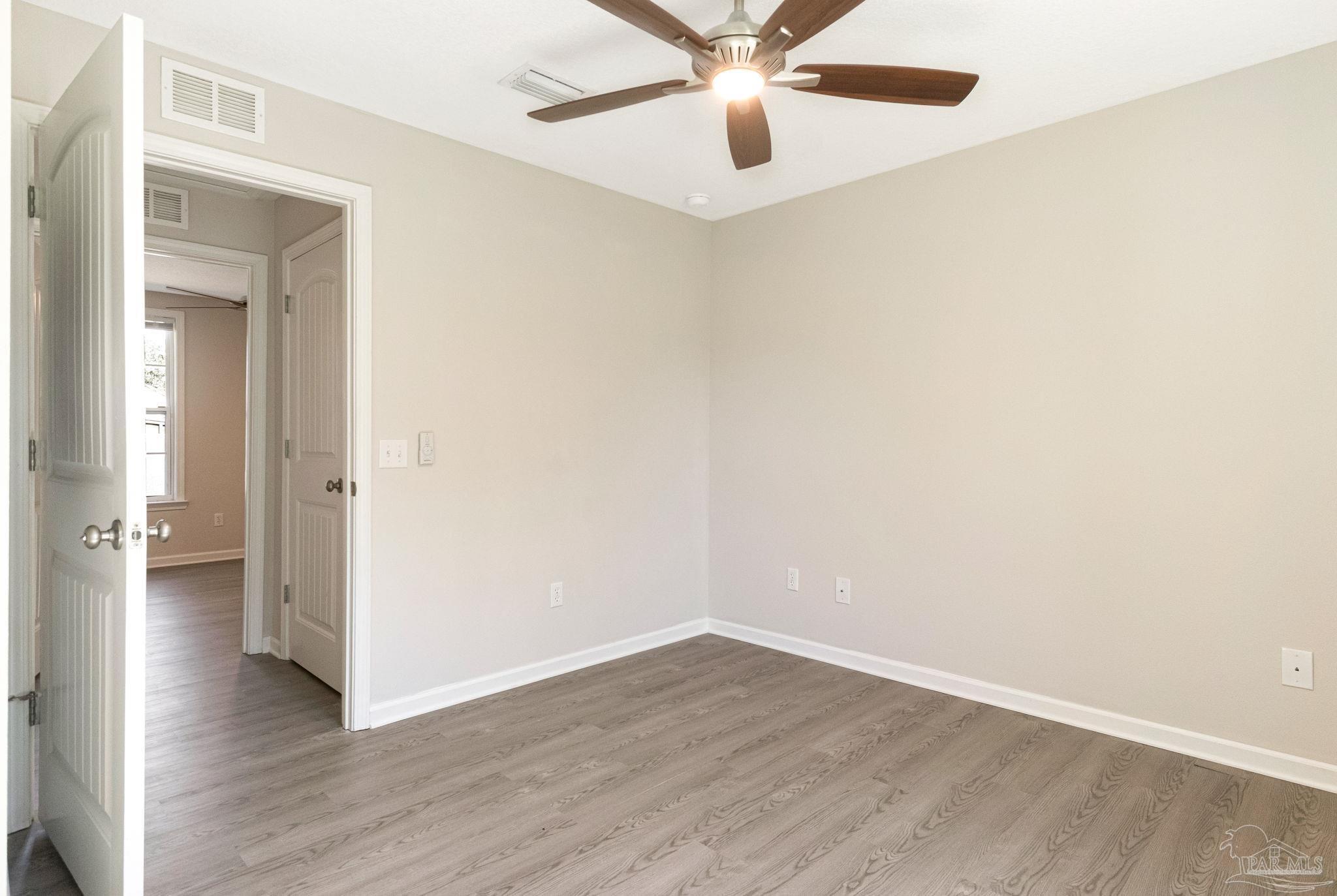 3152 Clemson Road Gulf Breeze, FL 32563 - Photo 21 of 56 an empty room with wooden floor and ceiling fan