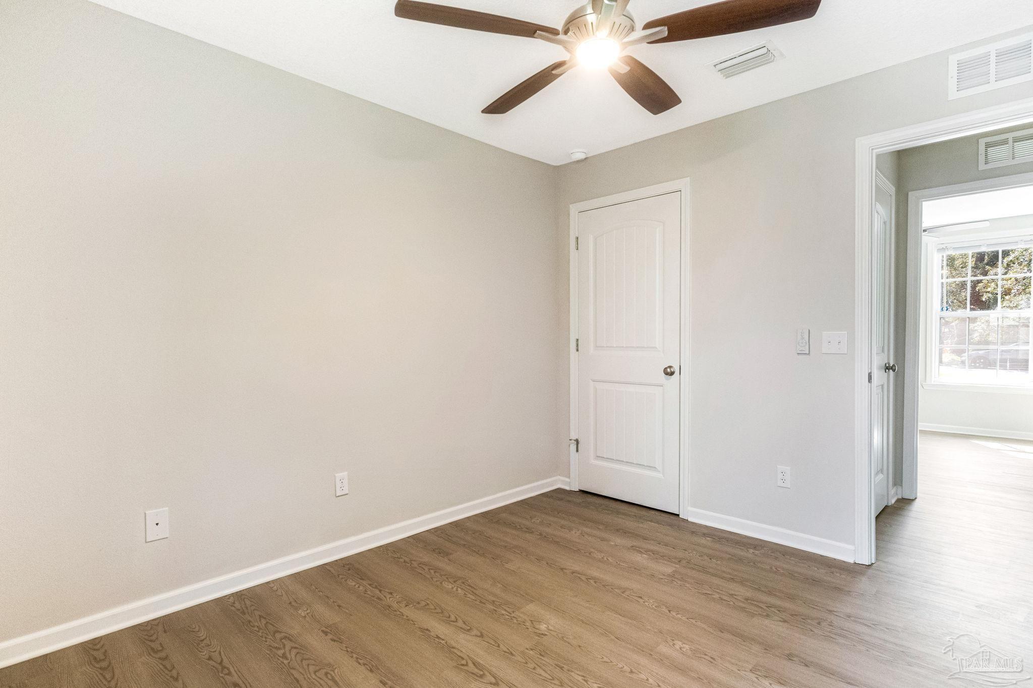 3152 Clemson Road Gulf Breeze, FL 32563 - Photo 23 of 56 an empty room with wooden floor fan and windows