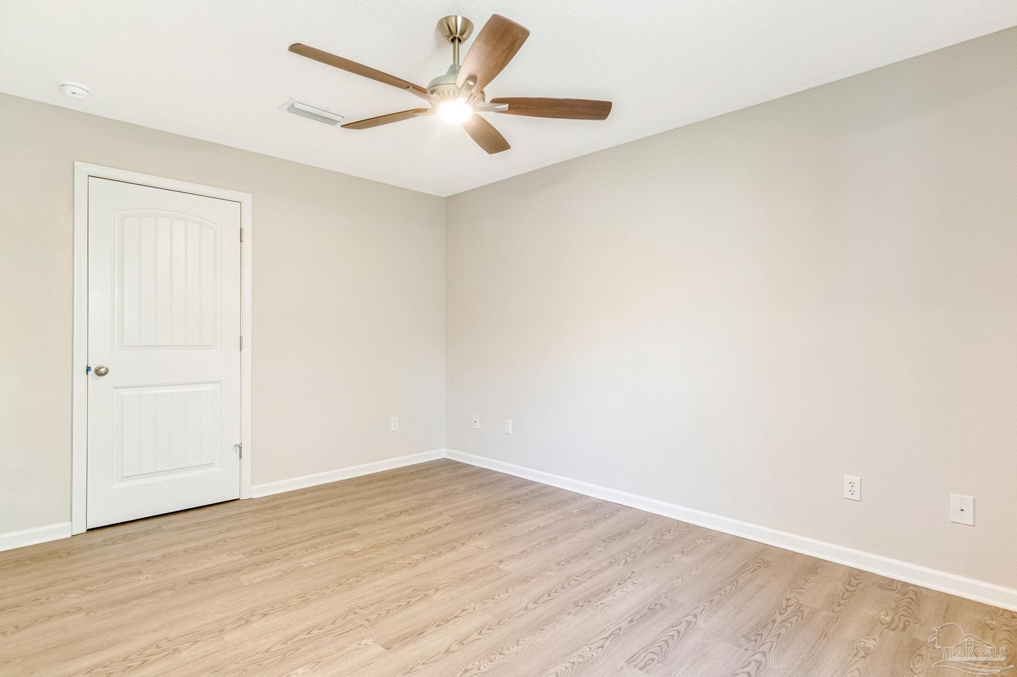 3152 Clemson Road Gulf Breeze, FL 32563 - Photo 30 of 56 an empty room with wooden floor and a ceiling fan