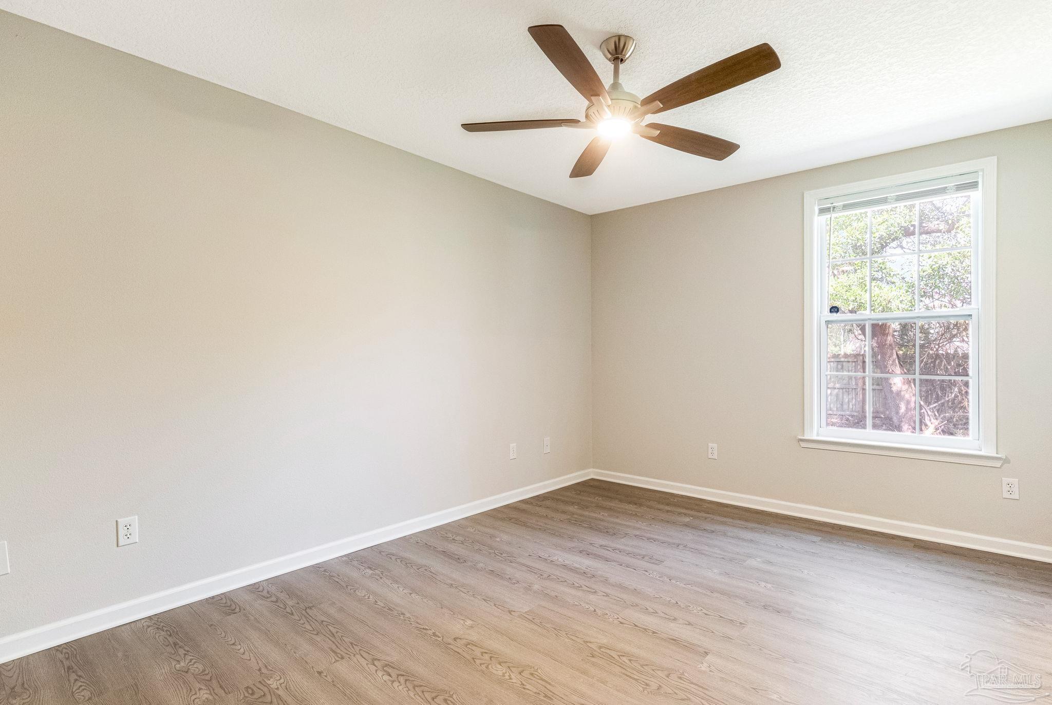 3152 Clemson Road Gulf Breeze, FL 32563 - Photo 31 of 56 an empty room with wooden floor and windows