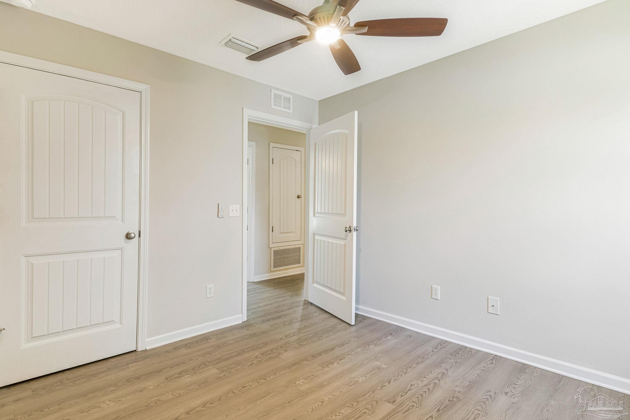 3152 Clemson Road Gulf Breeze, FL 32563 - Photo 33 of 56 an empty room with wooden floor closet and windows