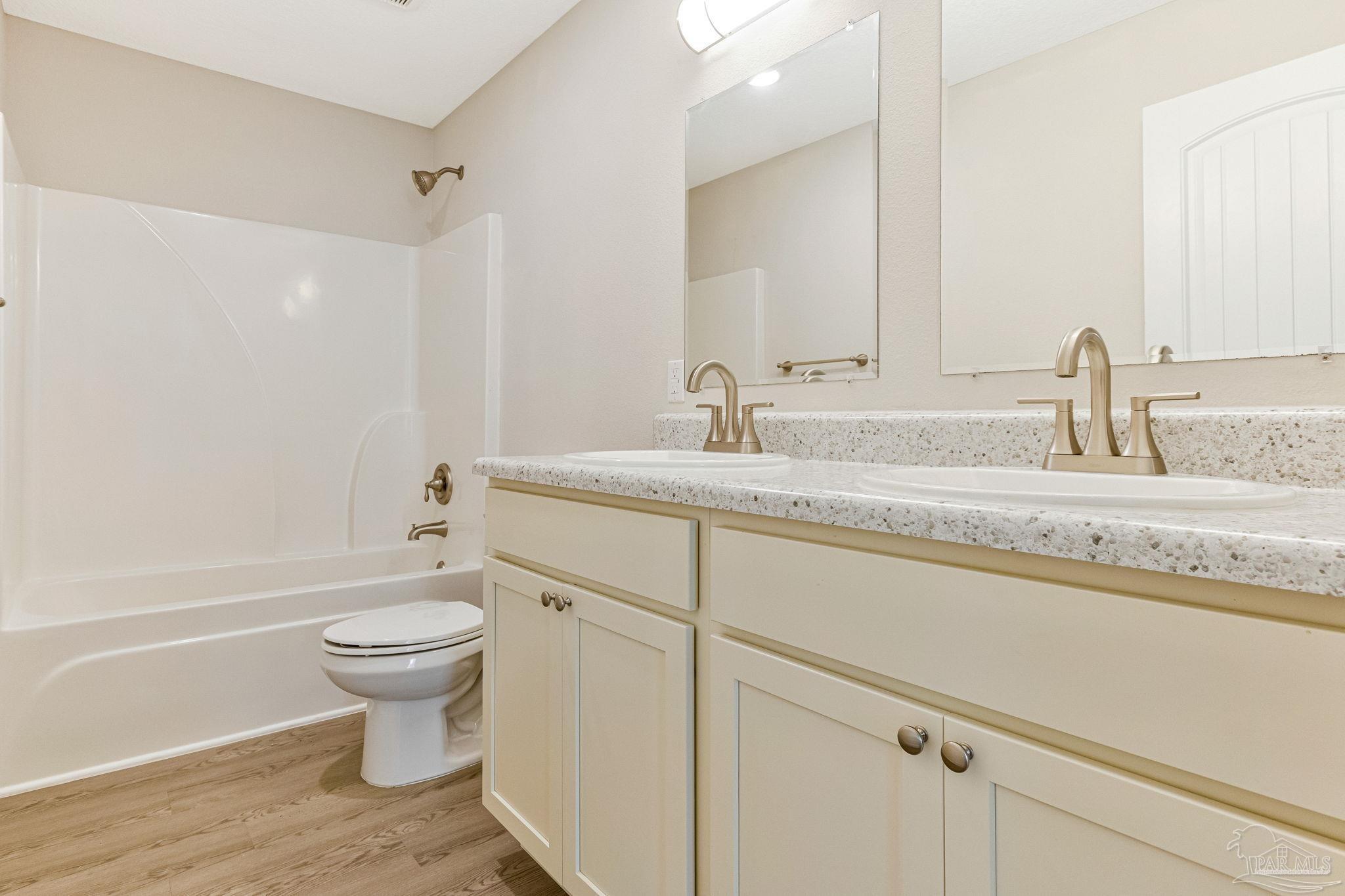 3152 Clemson Road Gulf Breeze, FL 32563 - Photo 34 of 56 a bathroom with a granite countertop toilet a sink and a bathtub