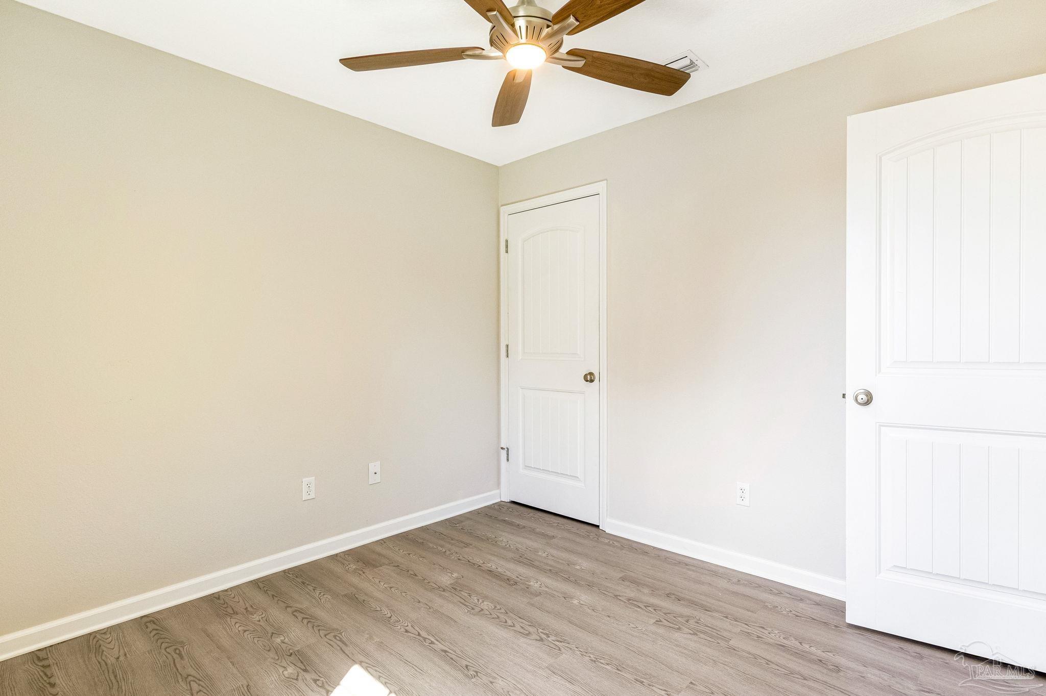3152 Clemson Road Gulf Breeze, FL 32563 - Photo 5 of 56 an empty room with wooden floor and fan