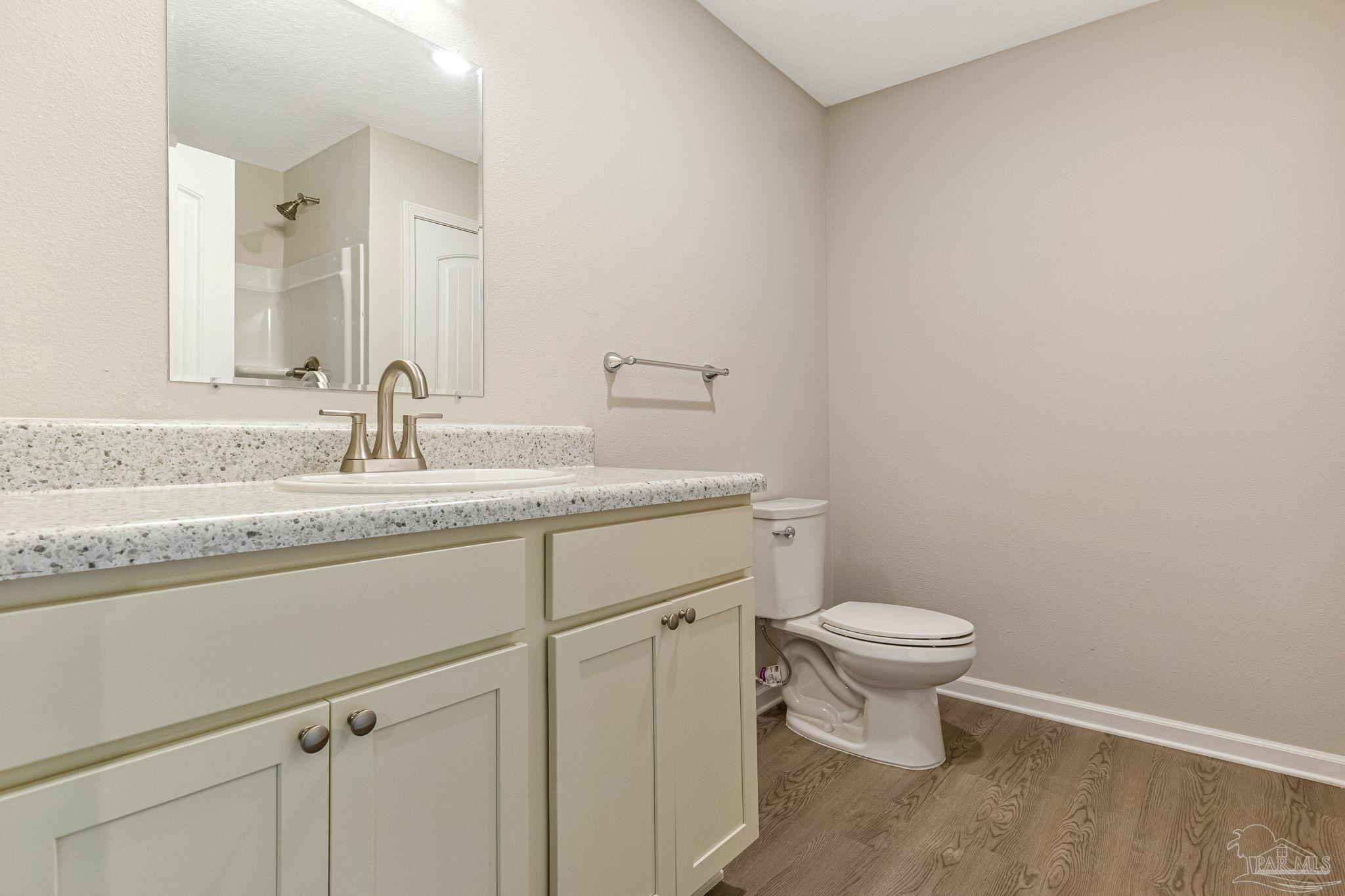 3152 Clemson Road Gulf Breeze, FL 32563 - Photo 6 of 56 a bathroom with a granite countertop sink a toilet and a mirror